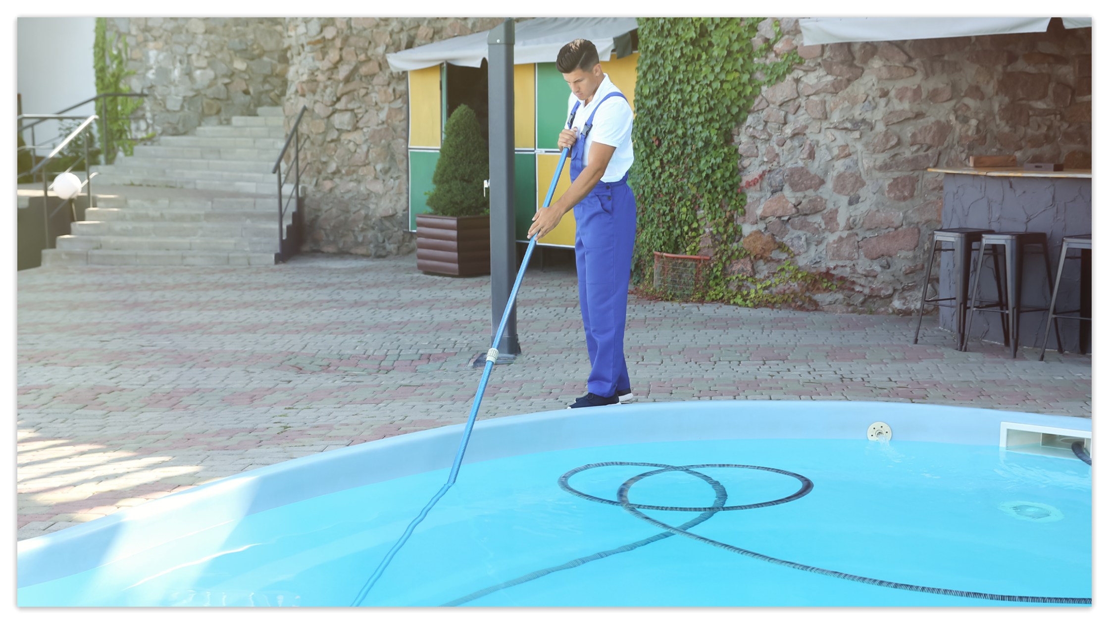 A professional is cleaning the swimming pool.