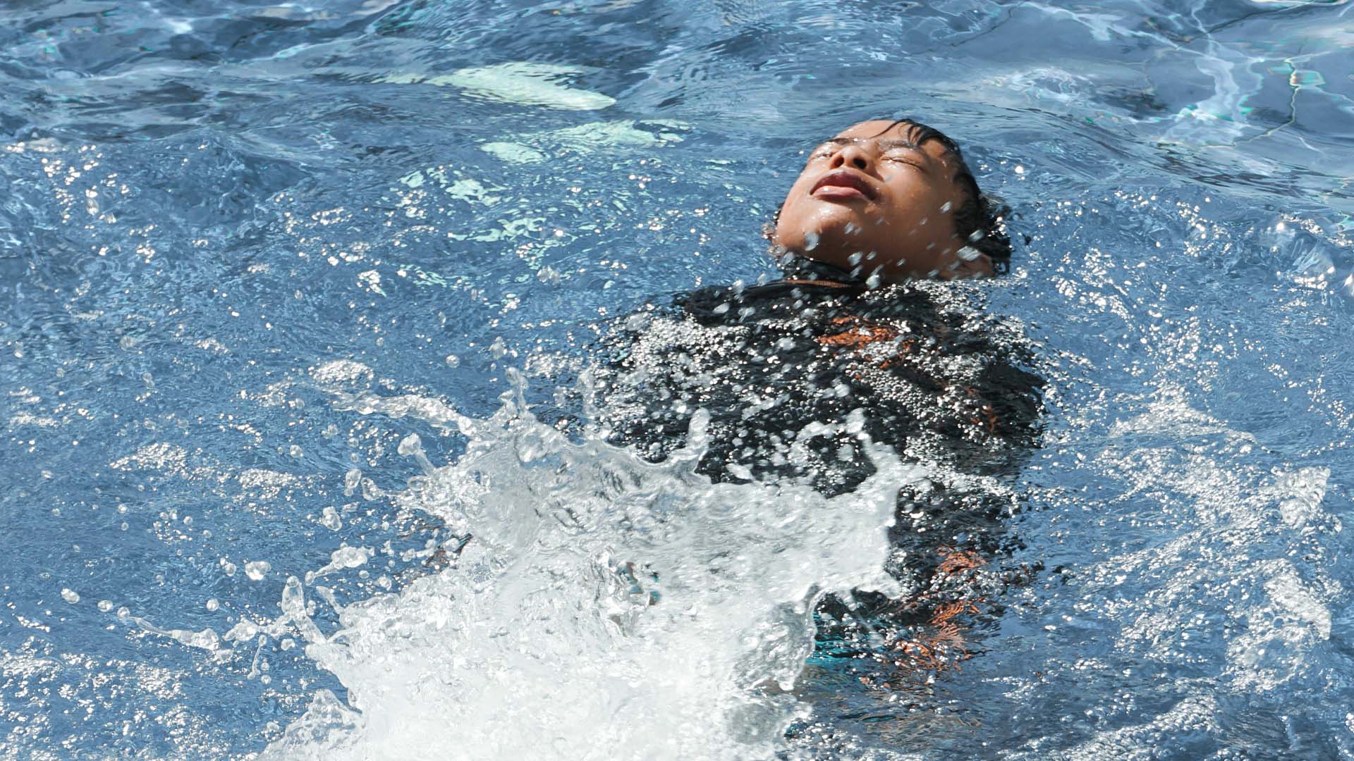 A boy swims in cold water.