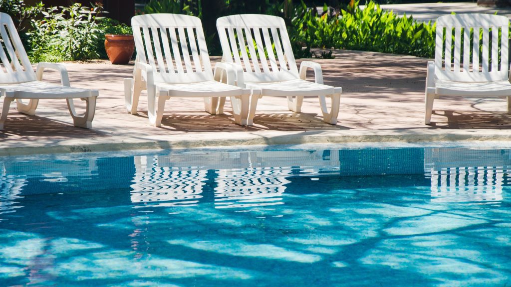 A fancy swimming pool with lounge chairs.